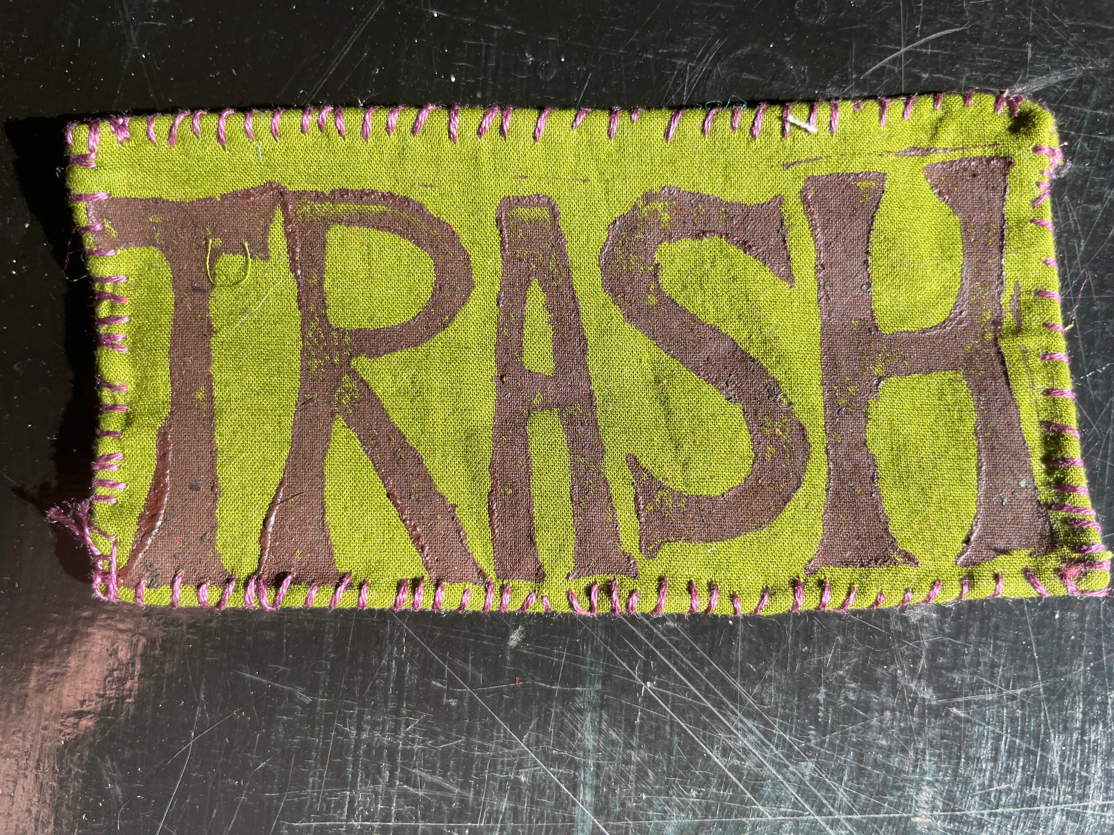 Fabric patch with 'TRASH' text on a green background
