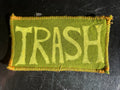 Green patch with 'TRASH' text on a dark textured background