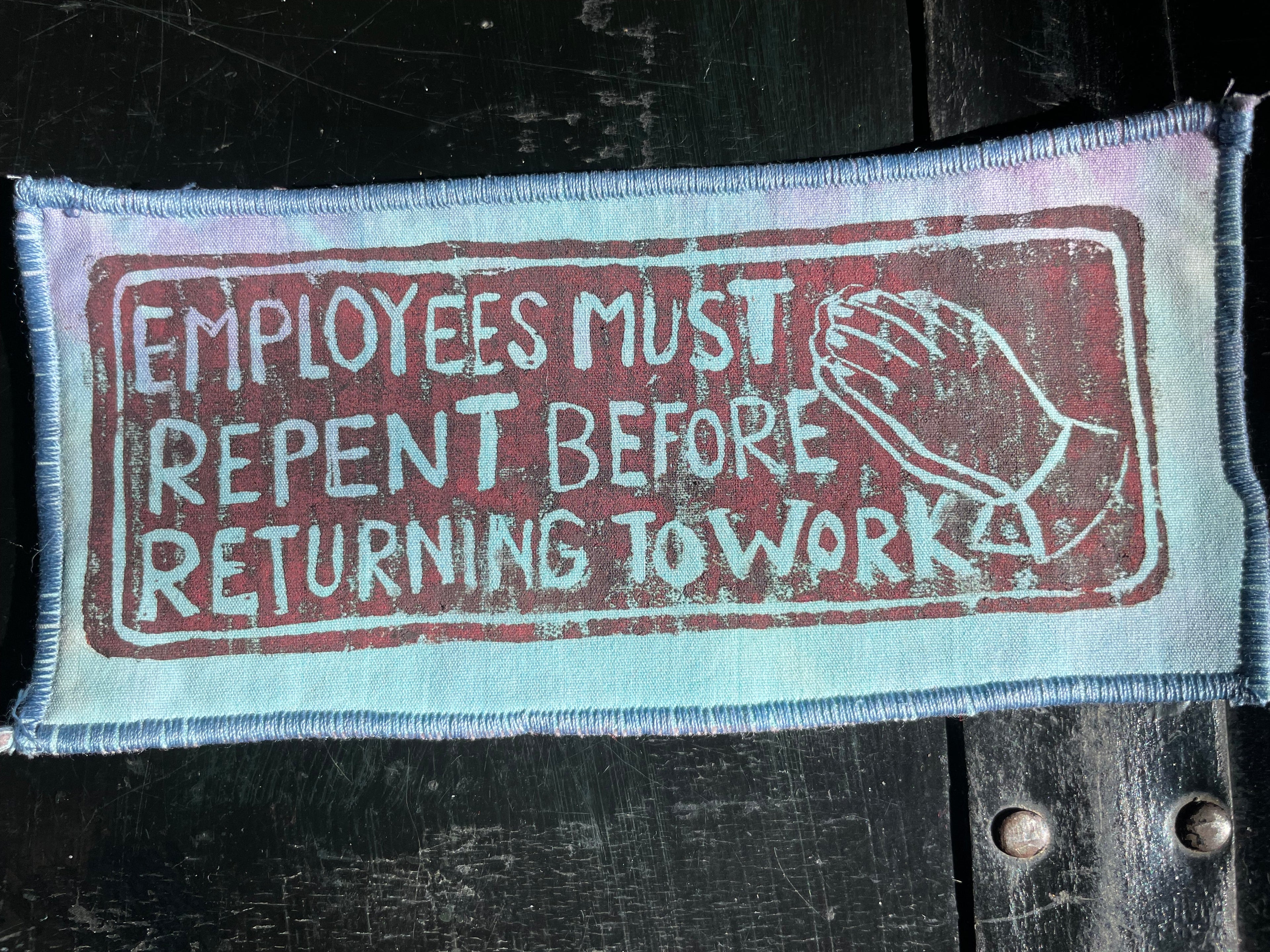 Tie Dye textile patch with printed message on a dark background